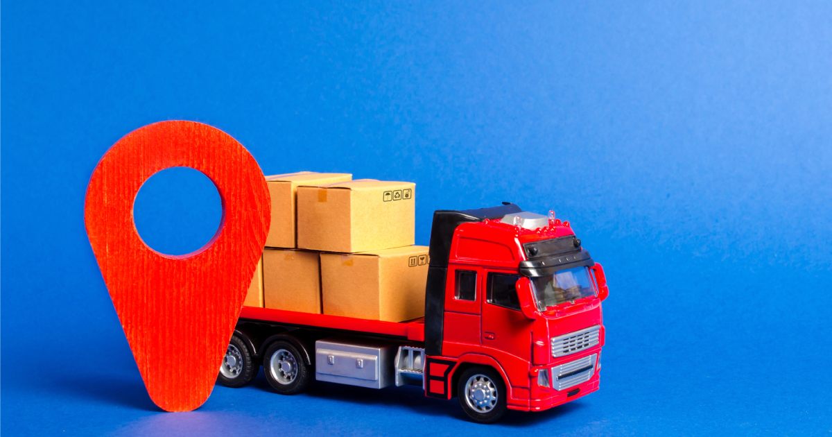A red truck loaded with boxes and a red pointer location