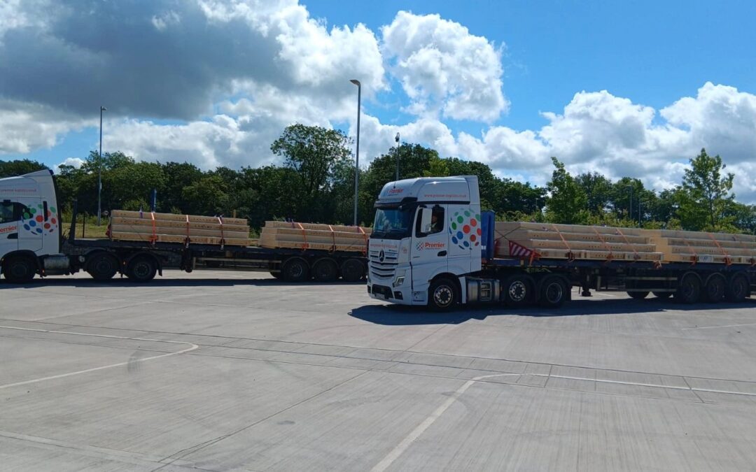 Two Premier Logistics white and orange flatbed trucks